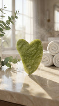 AuraStone green jade gua sha stone standing upright on a marble counter
